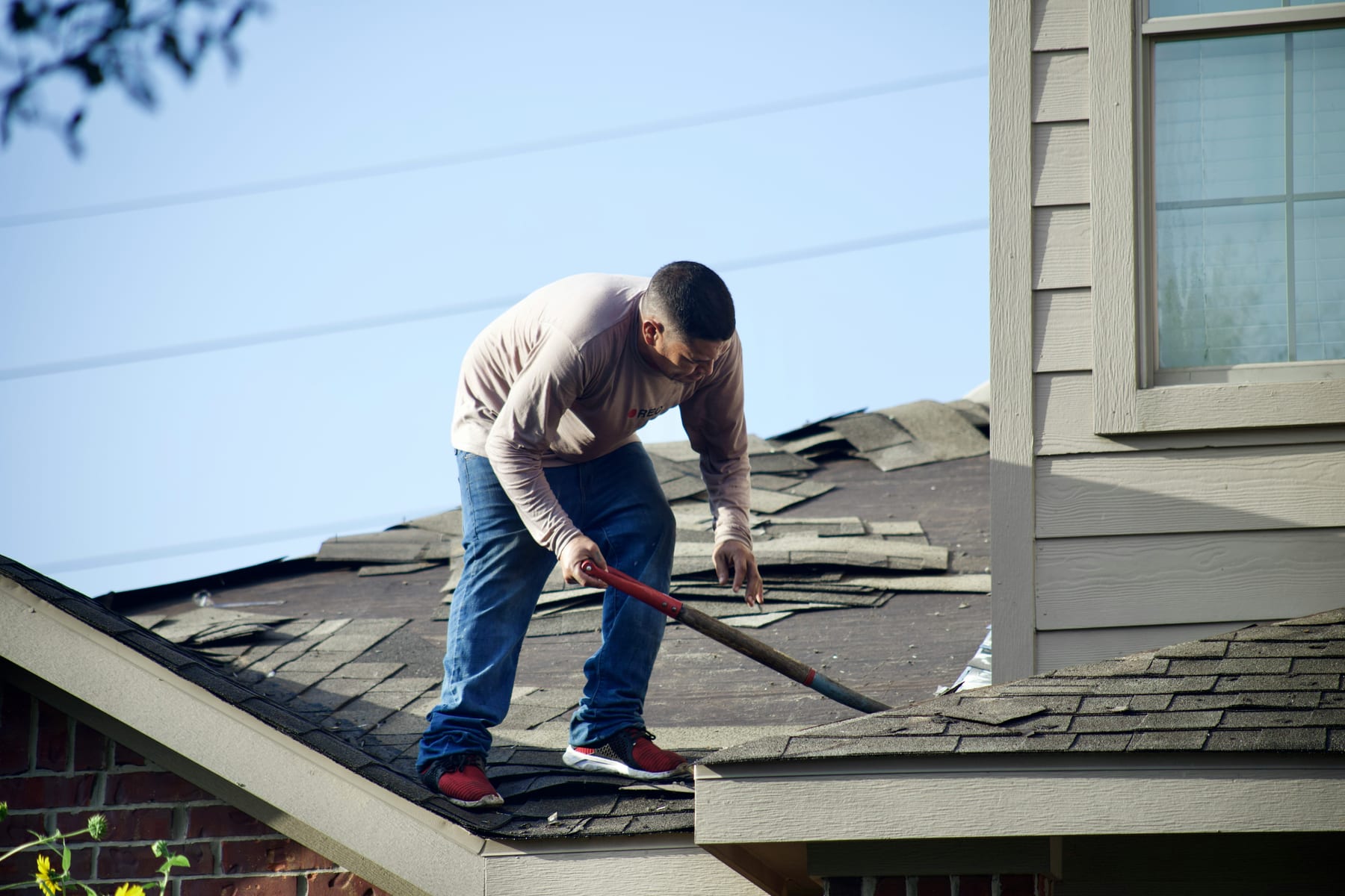 Roofer working on a shingle roof in Orange County, CA (North & South)